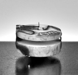 Mikroskopbild eines Metallkopfs, auf dem eine Gabel sitzt, auf der wiederum eine feine, nach oben ragende Spitze befestigt ist.