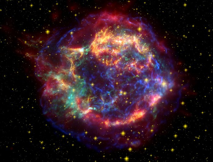 Der Supernova-Überrest Cassiopeia A Gaswolke mit filamentartiger Struktur vor Sternenhintergund.