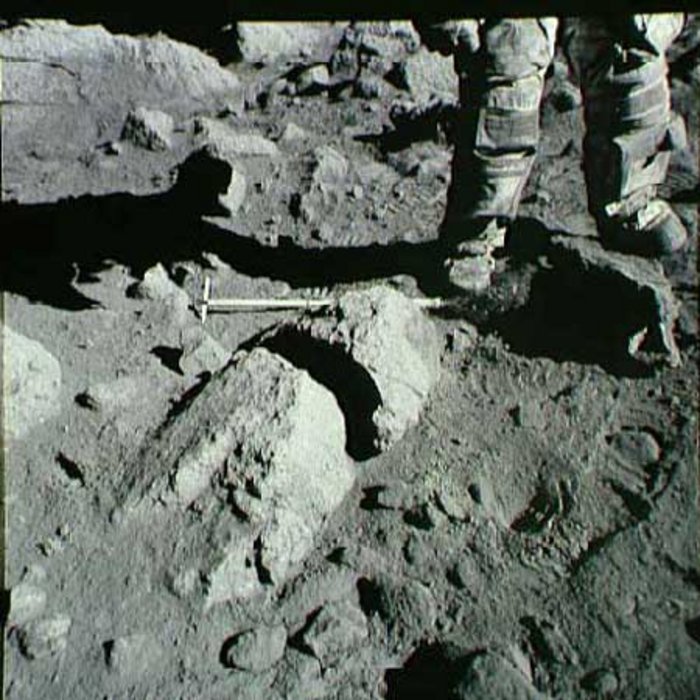 Aufnahmen der Mission Apollo 17 Auf einem steinigen Untergrund ist ein Bein eines Menschen zu sehen.