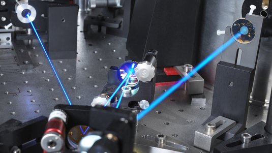 Das Foto zeigt einen Laserstrahl, der durch den Versuchsaufbau läuft.