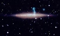 Dunkler Hintergrund mit vereinzelten leuchtenden Pünktchen, bei denen es sich um weit entfernte Sterne handelt. In der Mitte ein verschmierter Streifen: die Seitansicht einer Spiralgalaxie. Etwa mittig davon ragt ein kleiner (andersfarbiger) „Arm“ aus der Streifen, der zu einer Hintergrundgalaxie gehört.