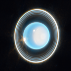 Blauer Planet im All umgeben von mehreren Ringen