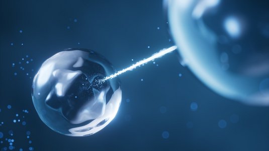 Auf einem dunklen Hintergrund sind zwei durchsichtige Kugeln abgebildet. Eine Kugel befindet sich im linken, die andere im rechten Bildbereich. Von der rechten Kugel geht ein leuchtender Strahl aus, der die linke Kugel trifft.