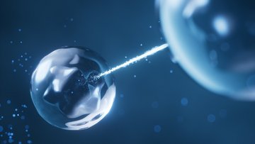 Auf einem dunklen Hintergrund sind zwei durchsichtige Kugeln abgebildet. Eine Kugel befindet sich im linken, die andere im rechten Bildbereich. Von der rechten Kugel geht ein leuchtender Strahl aus, der die linke Kugel trifft.