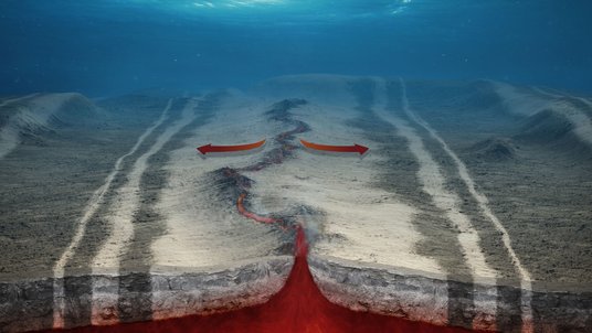 Grafische Darstellung des Meeresbodens: Durch eine graue Erdoberfläche unter Wasser verläuft ein Riss. Darunter zeigt rötliche Färbung das Magma an, dass sich unter dem Riss befindet.