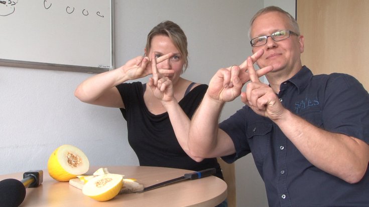 Zwei Menschen zeigen "F" mit den Fingern