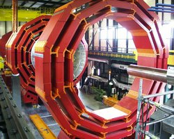 Foto von mehreren riesigen, ringförmigen Konstruktionen aus Eisen, die hochkant in einer mehrstöckigen Montagehalle aufgebaut sind und den gesamten Raum vom Fußboden bis zur Hallendecke einnehmen.