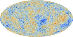 Eine ovale Karte zeigt den kosmischen Mikrowellenhintergrund anhand verschiedener Farben an. Die Farben stellen die Temperaturschwankungen dieser Strahlung dar; in blauen Regionen ist sie ein wenig kälter, in roten Regionen ein wenig wärmer. 