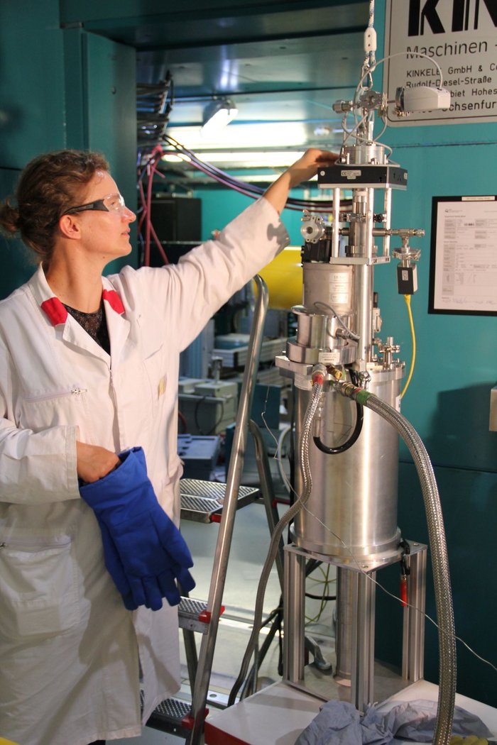 Gefriertrocknung der Probe Wissenschaftlerin mit Schutzbrille greift an eine hohe Apparatur