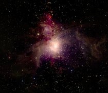 Die Molekülwolke Orion A wurde im infraroten Bereich des elektromagnetischen Spektrums abgebildet und ist hier (rot eingefärbt) vor dem Hintergrund der Galaxis zu sehen.