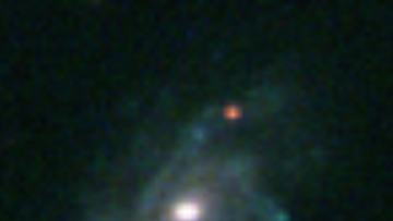 Im Zentrum ein hell leuchtender Punkt, umgeben von einer roten Wolke auf dunklem Hintergrund. Überall sind leuchtende Punkte zu sehen.