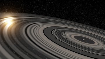 Planet mit ausgedehntem System aus Ringen, links scheint der Zentralstern durch die Ringe hindurch.