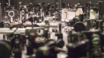 Linsen, Strahlteiler Polarisationsfilter und viele andere optische Instrumente im Labortisch arrangiert