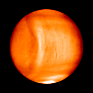 Eine Aufnahme der Venusatmosphäre. In der linken Hälfte der Venus ist eine bogenförmige Struktur zu erkennen.