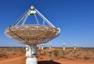 Mehrere Teleskope in einer Wüstenlandschaft.