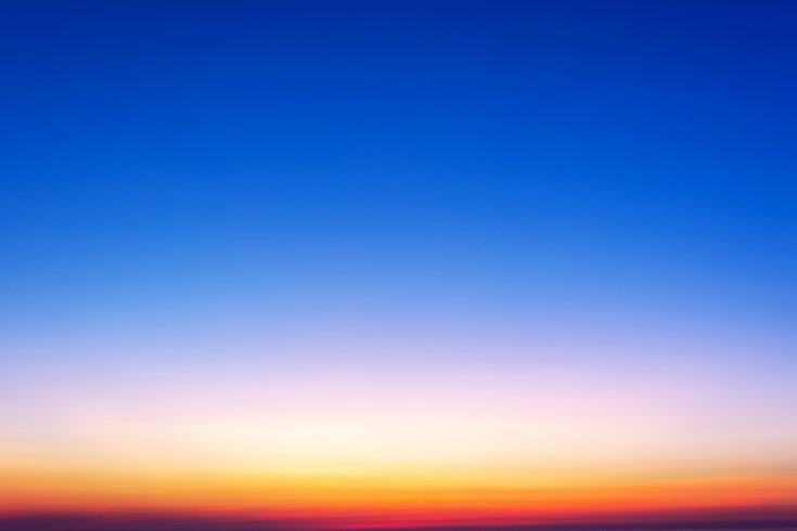 Himmel nach dem Untergang oder vor dem Aufgang der Sonne: Man sieht einen Farbübergang von einem starken Blau oben über ein helles Gelb in der Mitte bis zu einem dünnen Streifen dünnen Rots über dem Horizont.