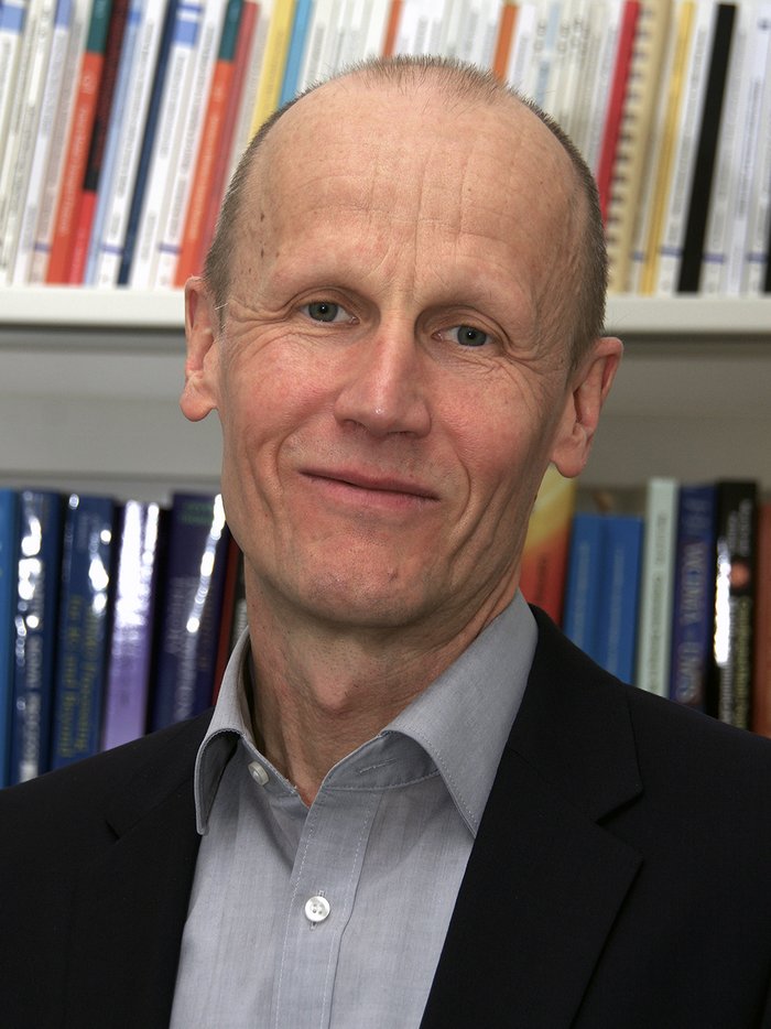 Armin Dekorsy Das Bild zeigt den Ingenieur vor einem Bücherregal.