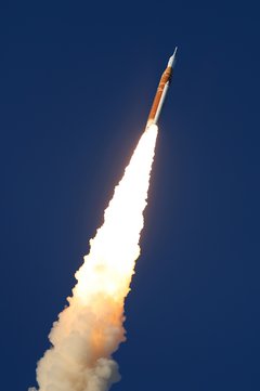 Eine Raumfahrtrakete stößt Flammen und Rauch aus und fliegt schräg nach oben