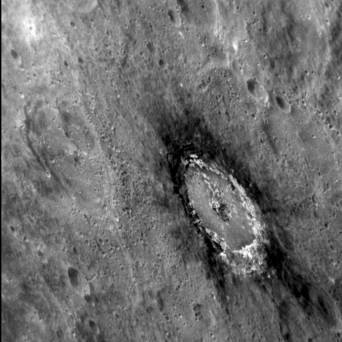 Krater auf Merkur Krater auf Planetenoberfläche, umgeben von einem Kranz aus dunklem Material.
