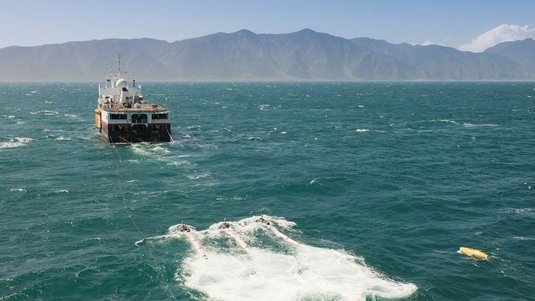 Ein Schiff im Meer vor Neuseeland zieht mit Seilen Sensoren durch das Wasser