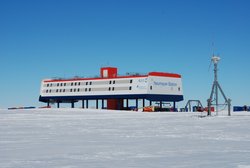 Foto: Kastenförmige Forschungsstation auf Stelzen in schneeweißer Ebene