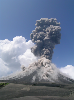 Foto: Vulkankegel mit grauer Eruptionswolke.