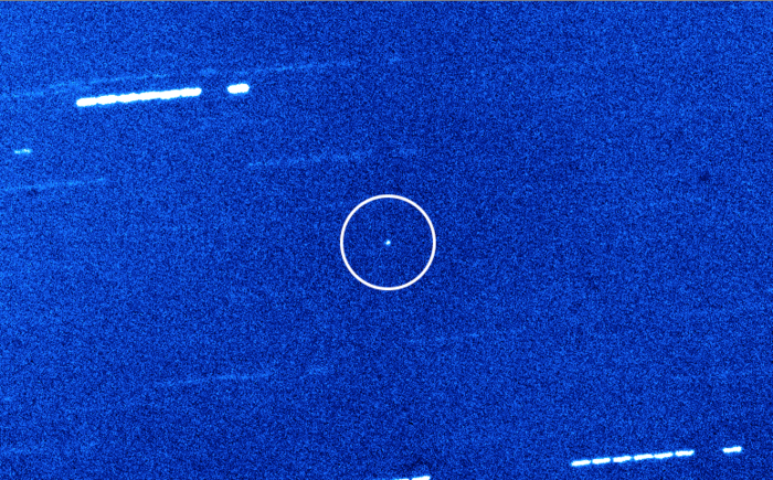 Aufnahme von Oumuamua Es ist eine Teleskopaufnahme des Sternenhimmels dargestellt. Der Himmelskörper Oumuamua in der Mitte ist mit einem Kreis kenntlich gemacht. Im Hintergrund befinden sich Sterne.