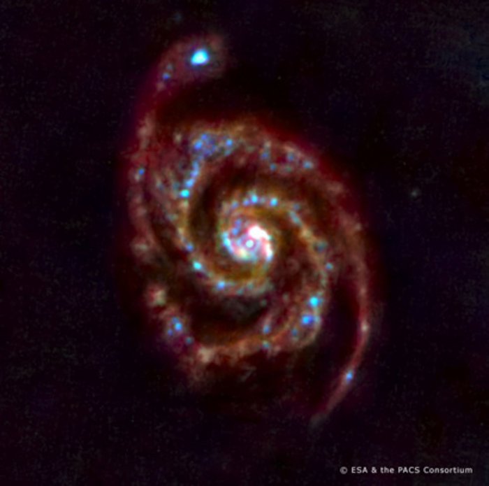 Rot-blau gefärbte Spiralgalaxie vor schwarzem Hintergrund