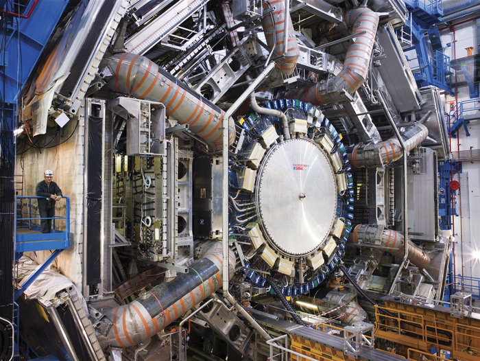 ATLAS-Detektor am LHC Runde Metallscheibe, größer als ein Mensch, auf die mehrere Metallrohre zulaufen.
