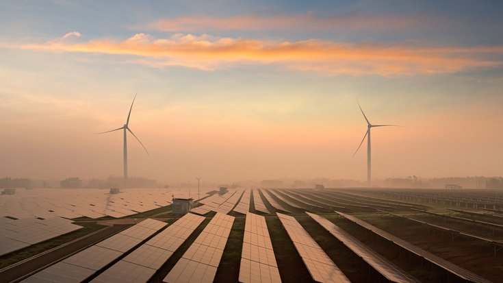 Das Bild zeigt verschiedene Reihe von Solarkollektoren und zwei Windräder.