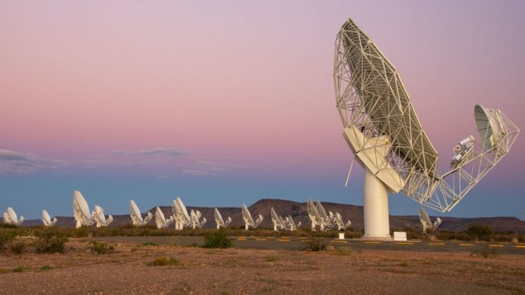 Radioteleskop MeerKAT | Bildquelle: South African Radio Astronomy Observatory Das Bild zeigt viele Teleskopantennen, die in einer kargen Landschaft stehen.