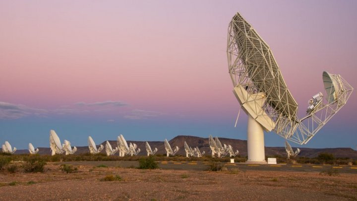 Das Bild zeigt viele Teleskopantennen, die in einer kargen Landschaft stehen.