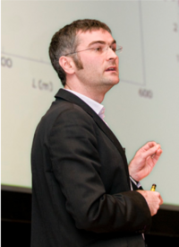 Das Bild zeigt den Forscher während er einen Vortrag hält.