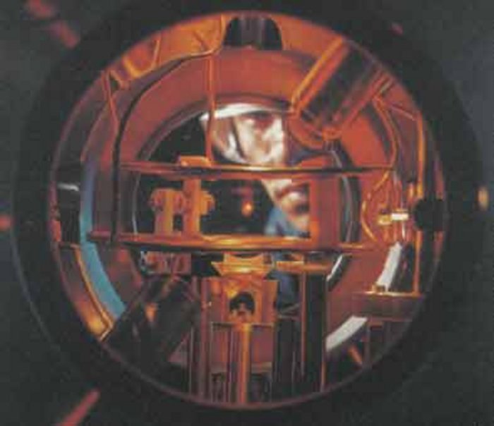 Blick in eine magnetooptische Atomfalle Ein Mann schaut von hinten in das Innere einer Vakuumkammer.