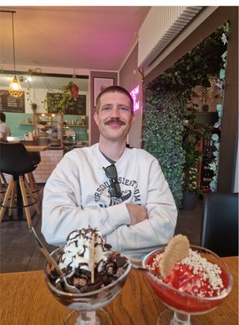 Porträt des Wissenschaftlers Hans-Georg Steinrück, der in einem Café sitzt. Vor ihm stehen zwei Eisbecher.