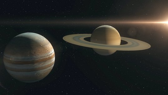 Die Planeten Jupiter und Saturn vor einem Sternenhimmel. Ein großes Licht ist am Rande zu sehen.