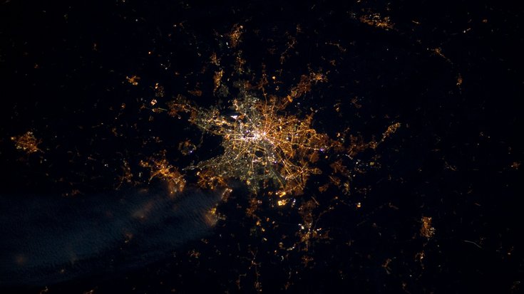 Satellitenaufnahme einer Stadt bei Nacht: Lichter bilden ein eng geknüpftes Netzwerk