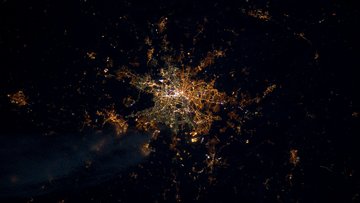 Satellitenaufnahme einer Stadt bei Nacht: Lichter bilden ein eng geknüpftes Netzwerk