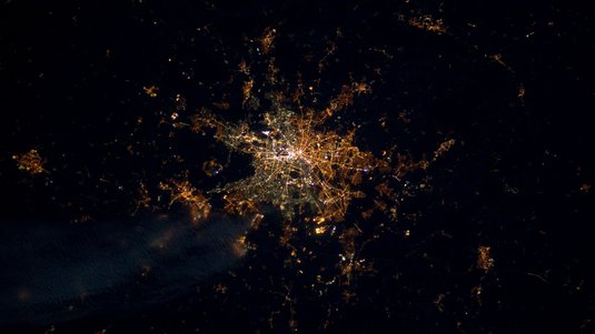 Satellitenaufnahme einer Stadt bei Nacht: Lichter bilden ein eng geknüpftes Netzwerk