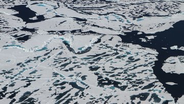 Großes Gewässer, aus der Luft fotografiert, dass weitgehend von Eis bedeckt ist