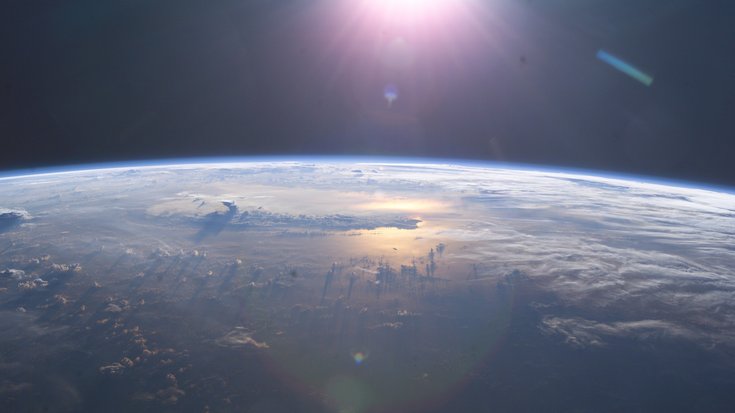 Erde von der ISS aus mit Blick auf den Sonnenaufgang über den Pazifik