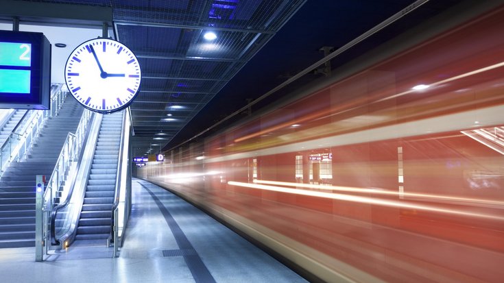 Bildquelle: querbeet/iStock Foto eines Bahnsteigs, auf dem eine Uhr sowie ein einfahrender Zug zu sehen sind.