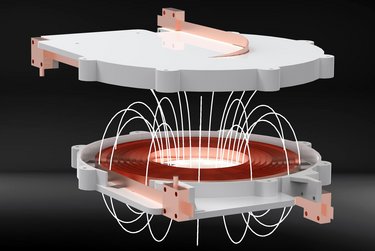 Grafik: Eine Spule im Inneren eines Bauteils, weiße Bögen zeigen Ladungsträger an, die sich zwischen der Spule und einem Bauteil darüber bewegen