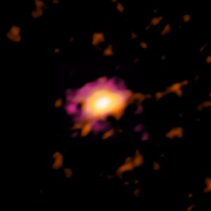 Verschwommene Aufnahme einer scheibenförmigen Galaxie im All: Heller Fleck in dunkler Umgebung, der zum Rand hin erst orange und dann violett wird.