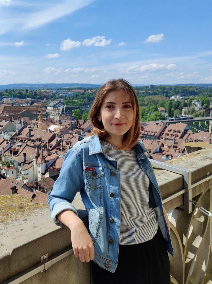 Sabina Raducan Das Bild zeigt die Forscherin, im Hintergrund sind Häuser und Bäume zu sehen.