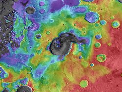 Ein Ausschnitt der nördlichen Hochebene Arabia Terra in Regenbogenfarben. In der Mitte Eden Patera, ein Krater, der als Einbruchskessel eines Supervulkans gedeutet wird.