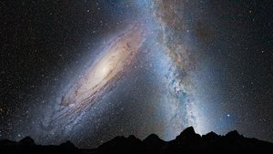 Vermutlich werden die Milchstraße und die Andromedagalaxie in einigen Milliarden Jahren kollidieren und miteinander zu einer elliptischen Galaxie verschmelzen. Diese Illustration zeigt das Bild, das sich am irdischen Himmel in diesem Fall zeigen könnte: Links ist die Andromedagalaxie zu sehen, eine Spiralgalaxie, die bereits anfängt, die Milchstraße (rechts) durch ihre Schwerkraft zu beeinflussen.