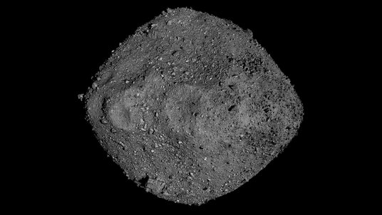 Die Aufnahme der Raumsonde OSIRIS-REx zeigt einen grauen Himmelskörper, dessen Oberfläche von Geröll übersät ist.