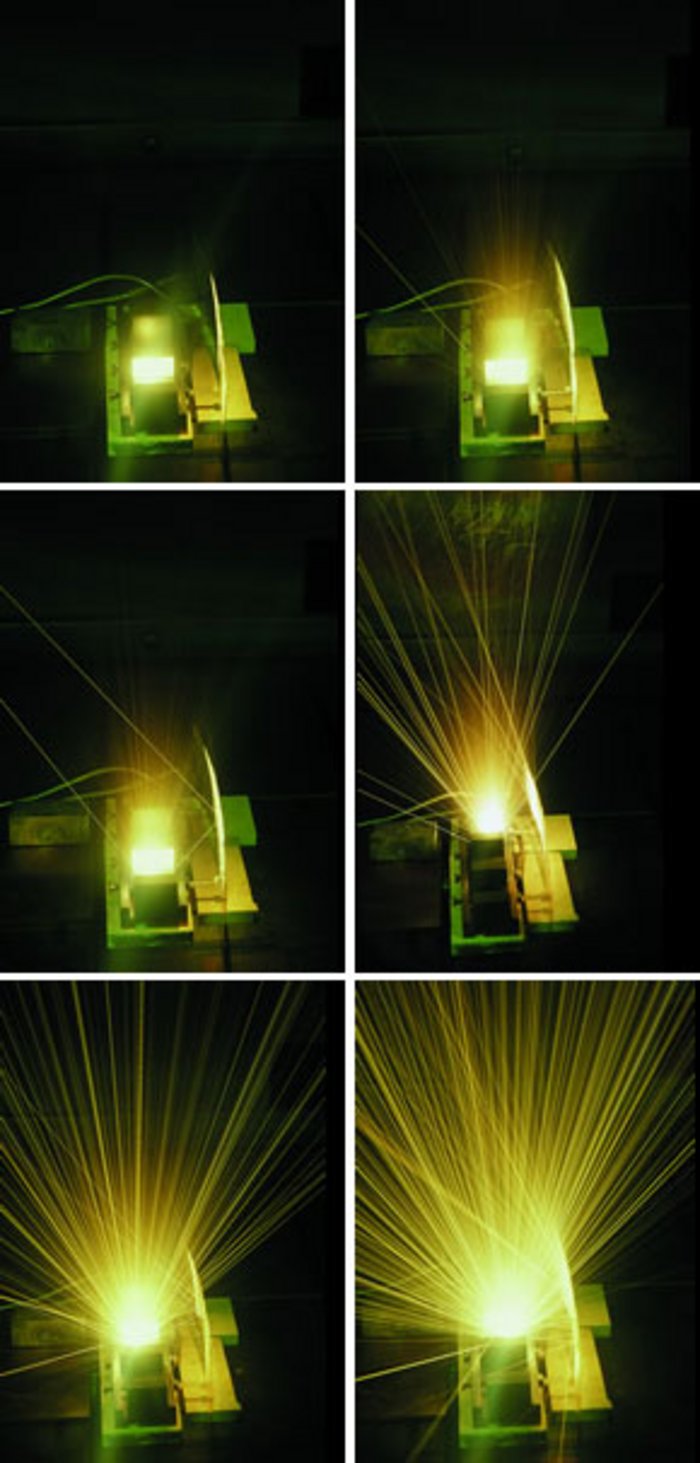 13 mA (Feinkorngraphit unter Elektronenbeschuß) Hell leuchtende Rechteckfläche in grünlich schimmernder, verkabelter Kastenkonstruktion, rechts ein Reflexionsschirm, umgeben von Dunkel.