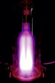 In einer durchsichtigen PET-Flasche leuchtet ein Stickstoffplasma. Die Flasche kann man so innen beschichten und damit zum Beispiel den Austritt von Kohlendioxid aus dem Getränk minimieren. 